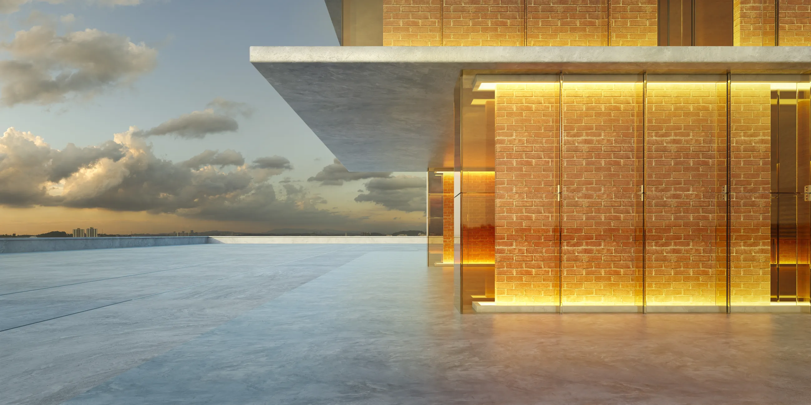 A modern building at dusk: a deep concrete canopy over a lit brick and glass facade, a bare terrace in front.