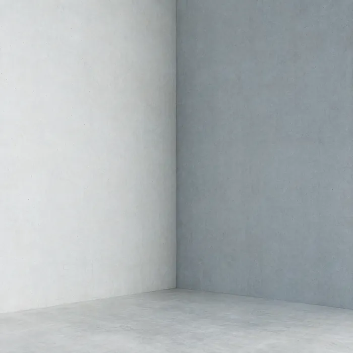 The inside corner where two pale concrete walls meet.