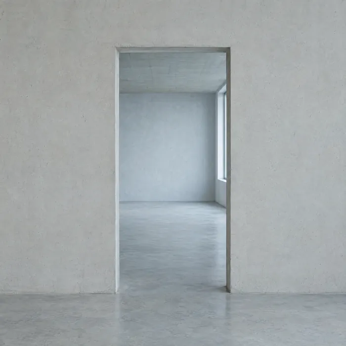 A plain doorway opening cut into a concrete wall.